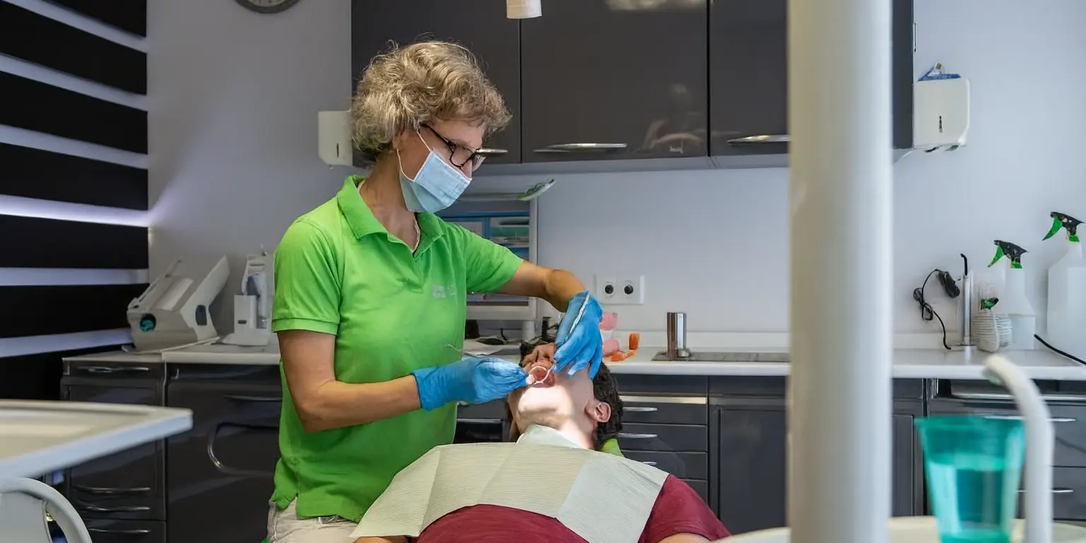 Darstellung einer Behandlung. Ein junger Mann bekommt eine Zahnfüllung.